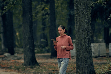 young woman in casual clothes is relaxing in an old park