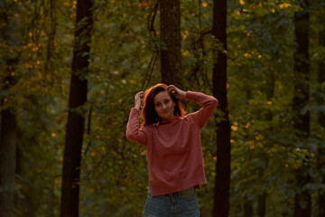 young woman in casual clothes is relaxing in an old park