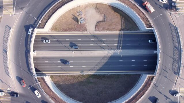 Aerial top down view of cars moving along the road junction.