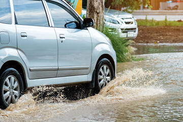 Car passing through a flooded road. Driving car on flooded road during flood caused by torrential...
