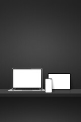 Laptop, mobile phone and digital tablet pc on black wall shelf. Vertical background