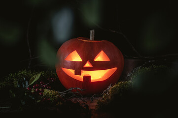 The carved face of pumpkin glowing on Halloween