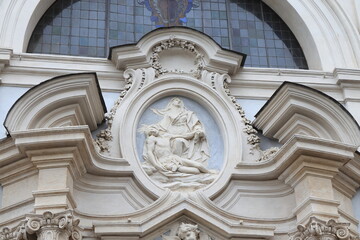 Fototapeta na wymiar Santi Bartolomeo ed Alessandro dei Bergamaschi Church Exterior Sculpted Detail with Pietà Relief in Rome, Italy