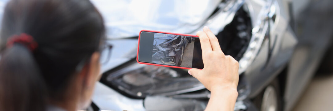 Agent takes smartphone photo of damage to car after accident