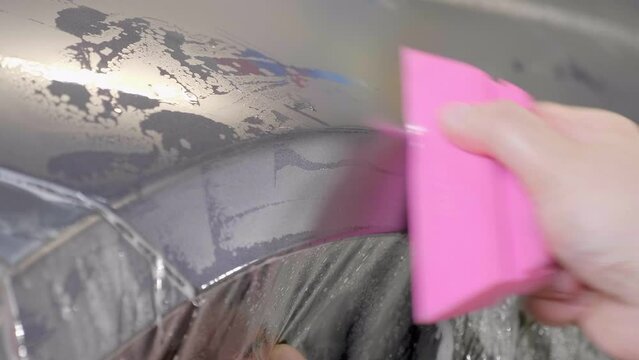 Specialist Wrapping Car with Transparent Foil, Close Up Hands and Tool