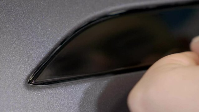 Detailing Car Wrapping Vinyl on Exterior Body Part with Small Tool.