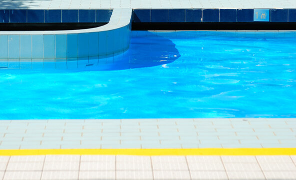 Blue outdoor swimming pool on a summer day.