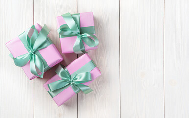 Three pink gift boxes on a light background. The concept of holidays. Top view, horizontal