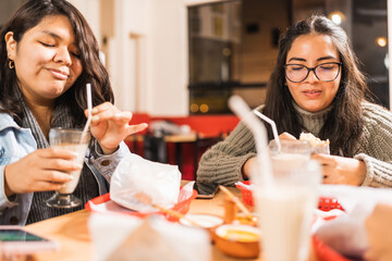 Women in a table of a restaurant drinking milkshake