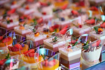 Beautiful and bright desserts on the festive table for the party. Confectionery with cream