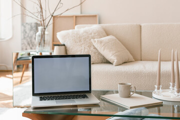Laptop computer on coffee table in modern Scandinavian home interior. Minimal style, light colors.  Aesthetic elegant blog, online shop, store, social media.