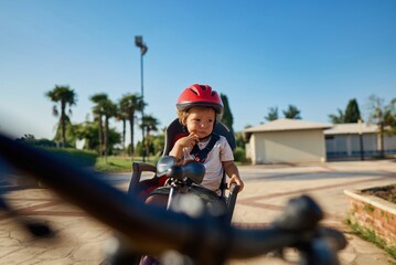 cute little boy with big bike outdoors in city street. High quality photo