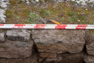 Two ranging poles and a trowel during an archaeological excavation. Archeology works