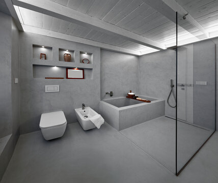modern bathroom interior covered in grey resin with tub and shower in masonry