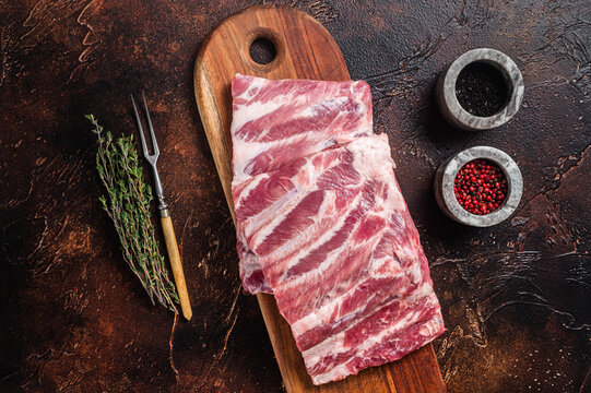 Raw Pork Spare Loin Ribs St Louis On Wooden Board With Herbs. Dark Background. Top View