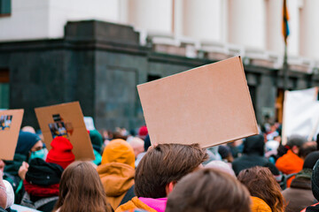 A guy with a paper banner in their hands protests on the street. Young. Outdoors. Protester....