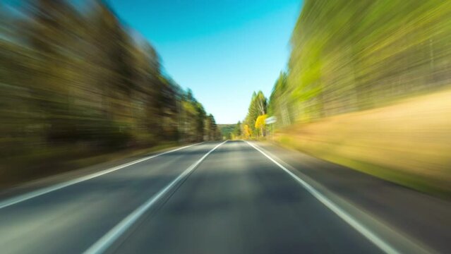 Fast Car Hyperlapse.Car Driving On Country Road in Forest. 4K Point of View Hyperlapse Time-lapse. Trees Stretch on Both Sides Of Road. Road Trip Travel Dashcam POV