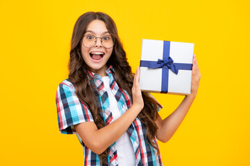 Amazed teen girl. Child with gift present box on isolated background. Presents for birthday, Valentines day, New Year or Christmas. Excited expression, cheerful and glad.