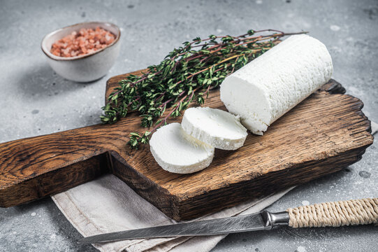 Fresh goat soft cheese with thyme. Gray background. Top view