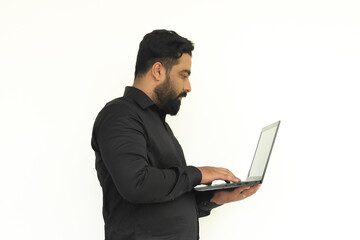 Selective focus of Indian young businessman standing, holding laptop .Isolated over white background.