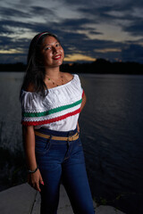 Joven en traje tipico mexicano con vista de laguna en un atardecer 