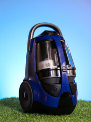 Naklejka premium Blue vacuum cleaner on light blue gradient background. Home appliances.