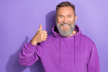 Photo of aged pensioner attractive grandfather bearded showing thumb up good mood recommend new product isolated on purple color background