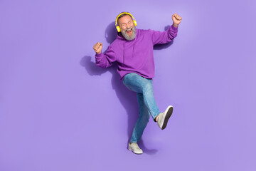 Fototapeta na wymiar Portrait of retired funny carefree man dressed purple hoodie headphones dancing listen best songs isolated on violet color background