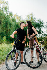 Fototapeta premium Young loving couple kissing on the bicycles