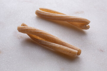 whole durum wheat pasta on white marble