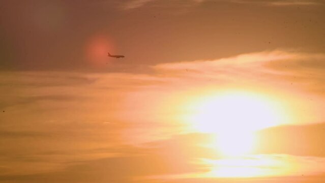 Plane flying over the sunset and clouds preparing for landing