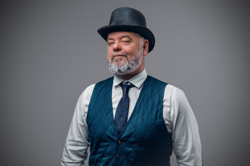 Studio shot of elegant elderly man dressed in costume from past with top hat.