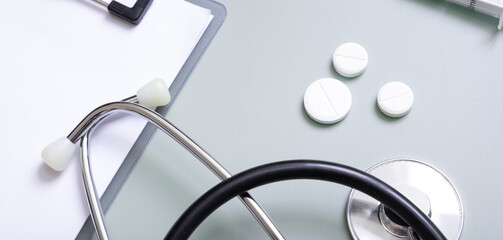 Banner with stethoscope, pills and tablet at doctor's workplace on colored background top view