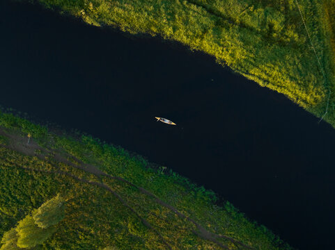 Aerial view of a canoe sailing the Torne River at sunset in Overtornea, Norrbotten, Sweden.