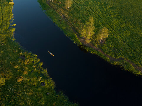 Aerial view of a canoe sailing the Torne River at sunset in Overtornea, Norrbotten, Sweden.