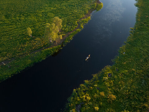 Aerial view of a canoe sailing the Torne River at sunset in Overtornea, Norrbotten, Sweden.