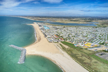 Aerial photo over West Sands at Selsey in West Sussex with a large holiday caravans park next to...