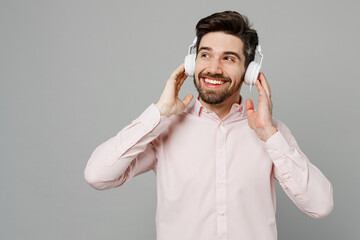 Young smiling minded cool happy cheerful caucasian man 20s he wearing basic white shirt headphones...