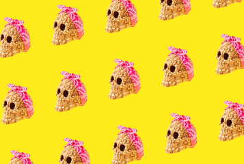 Tied pink bandana on skull head on vibrant yellow  background. Minimal pop art or halloween concept.