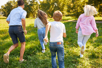 Glückliche Familie beim Laufen über eine Wiese