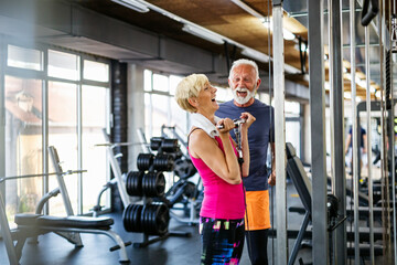 Happy senior people doing exercises in gym to stay fit. People sport concept.