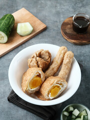 Pempek, Empek-Empek, traditional food from South Sumatra, Indonesia. This fish-based food is very popular. Served with cuko sauce and cucumber slices.

