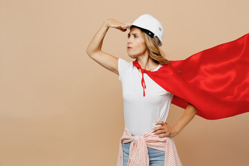 Side view young employee laborer handyman woman in white t-shirt helmet red cloak do super hero...