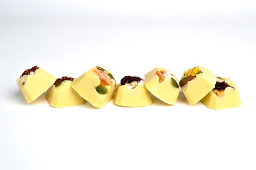 Set of handmade bonbons with berry fruit and nuts filling on pink background. Exclusive handcrafted chocolate candies.