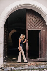 A young, slender blonde in beige pants and a black blouse walks the old streets of Lviv. Ukraine.
