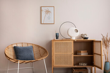 Interior design of cozy and summer living room with rattan armchair, commode, pillows, mock u poster frame, decoration, carpet and personal accessories. Stylish home decor. Template.	