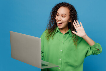 Young fun IT woman of African American ethnicity 20s she wear green shirt hold use work on laptop...