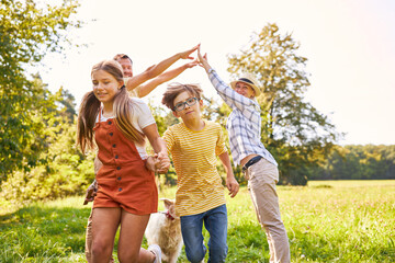 Fototapeta premium Eltern und zwei Kinder machen zusammen ein Spiel a