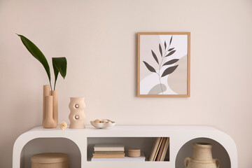 Interior design of harmonized living room with mock up poster frame, white commode, vase with leafs, decoration and personal accessories. Cozy home decor. Template. 