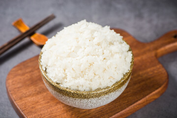 Hot cooked rice with smoke and steam in a bowl on table
